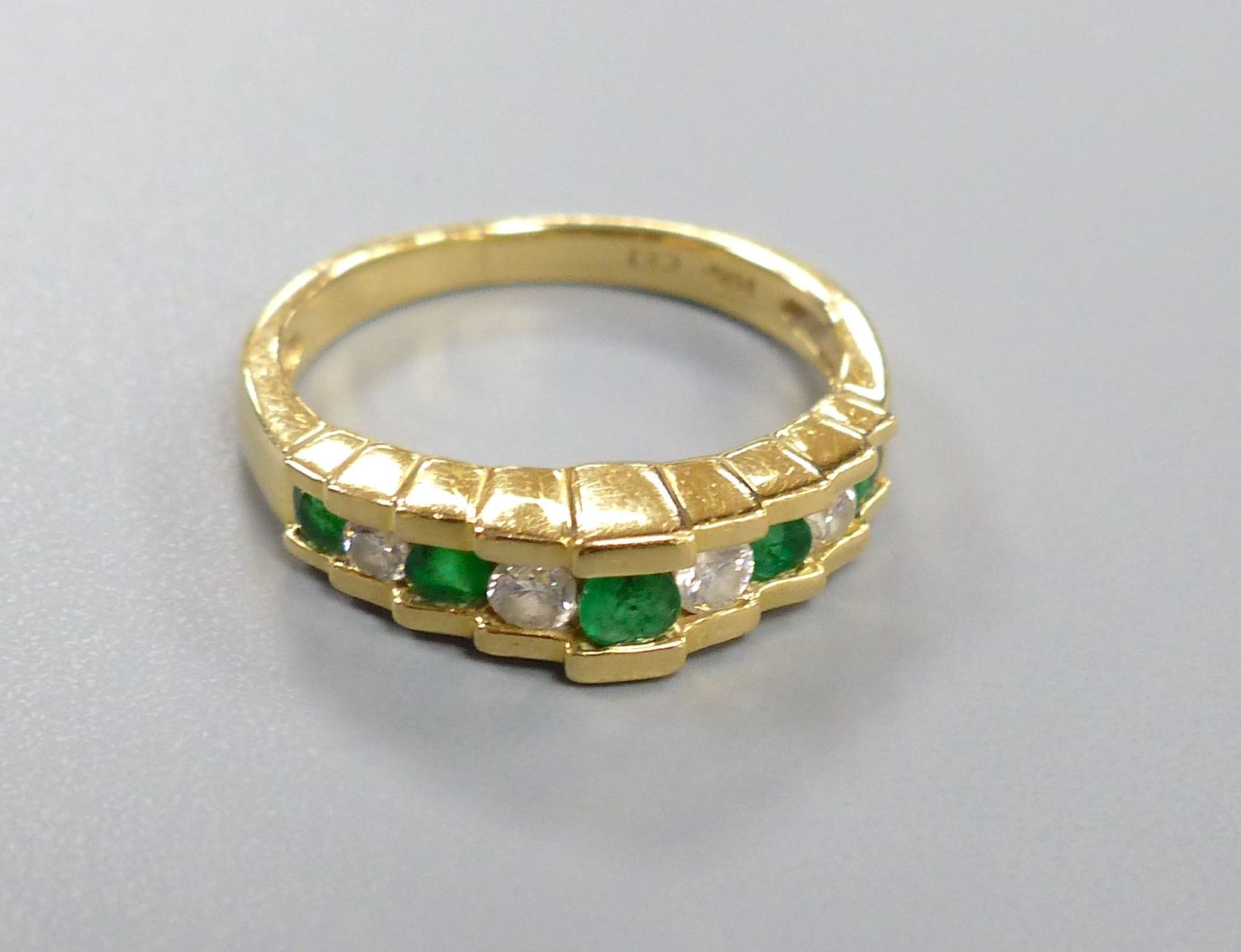 An Art Deco style emerald and diamond nine-stone ring in stepped setting, stamped 14K, size K, gross 3.5 grams.
